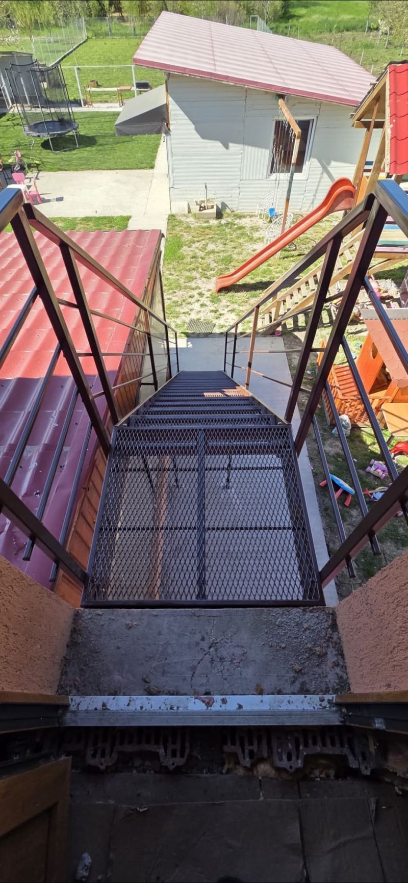 Scară metalică exterioară cu podest pentru acces la etaj